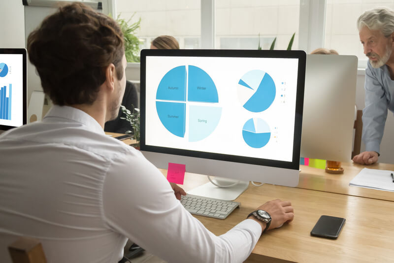Young employee using computer analyzing data, statistics analysis education concept